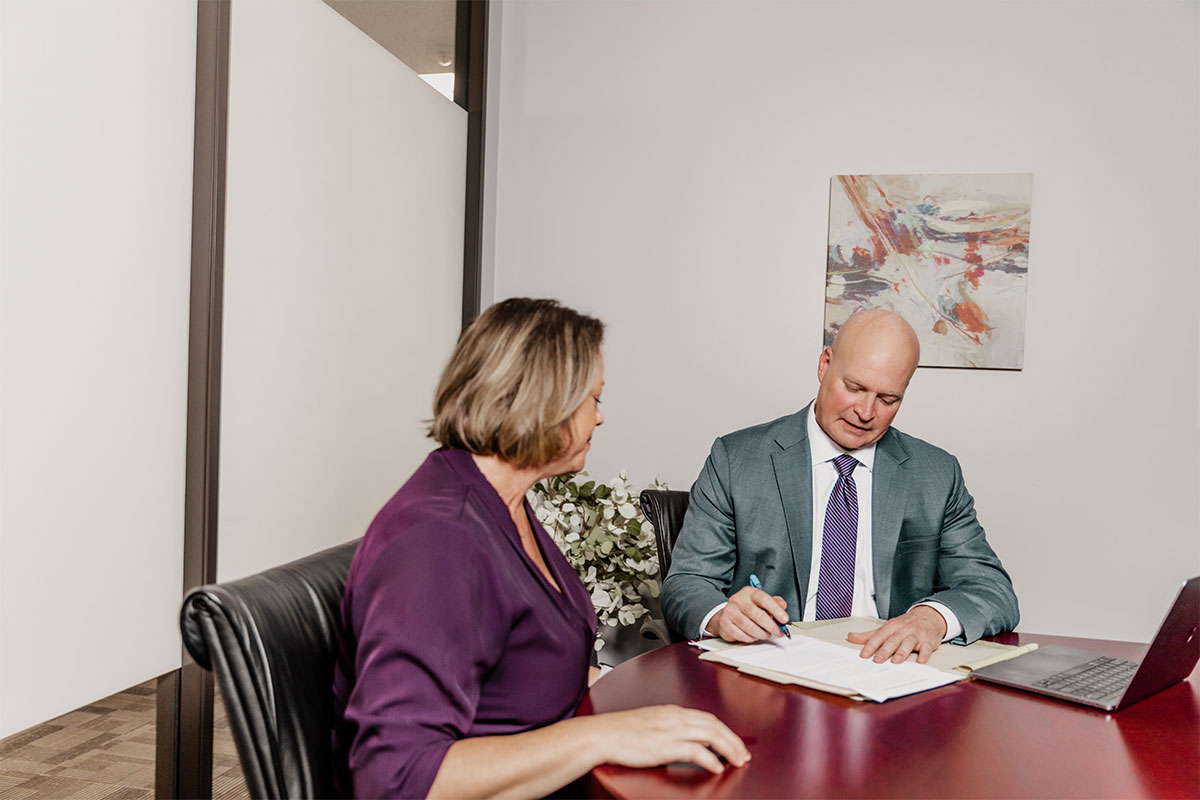 a commercial litigation lawyer in Houston meets with a business owner in a conference room to discuss a dispute